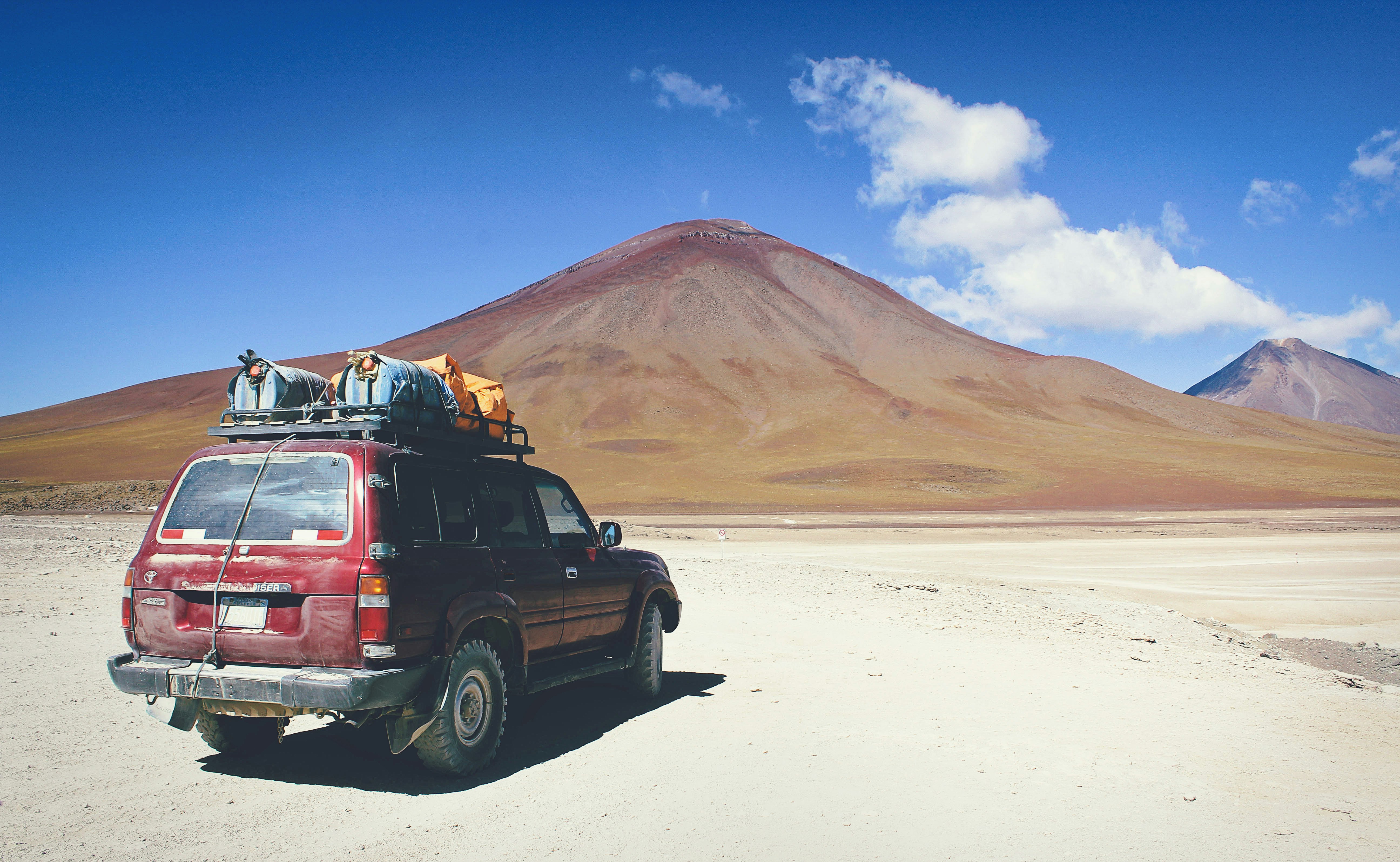 red SUV facing mountain